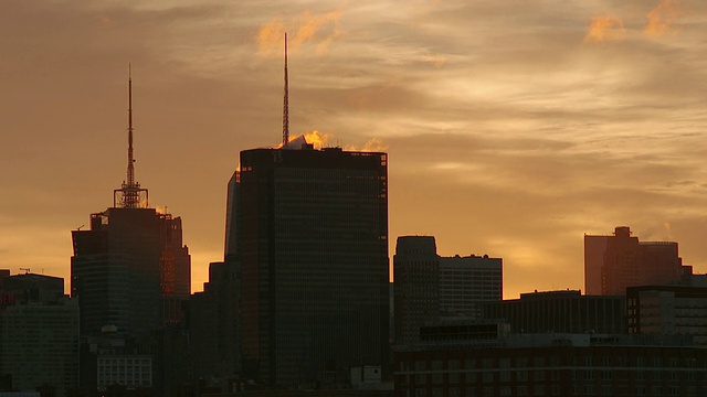 清晨，蒸汽从宾夕法尼亚广场1号的楼顶缓缓飘下。天空是橙色的，建筑物是剪影视频素材