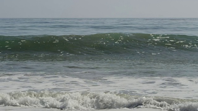 海浪上升，卷卷和碰撞，白浪隆隆地冲击着海滩，慢镜头视频素材