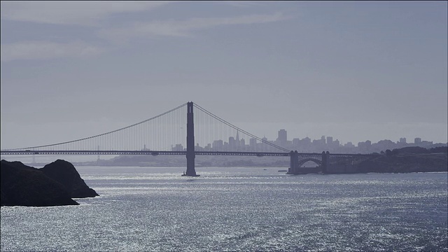 中等宽静态框架，建筑角度上金门大桥南塔，旧金山天际线的背景，清澈的蓝色天空视频素材