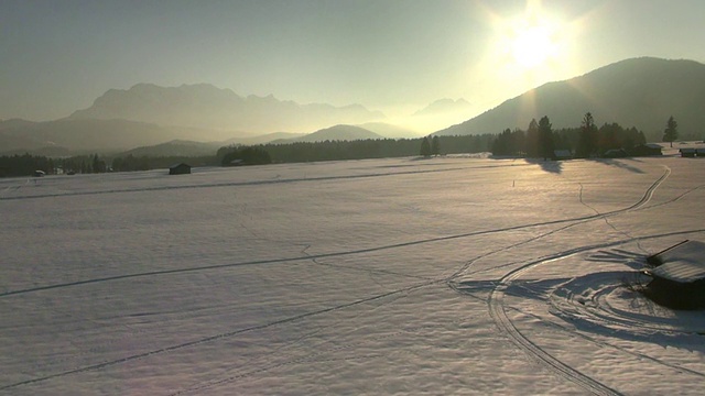 WS鸟瞰图白雪覆盖的草地与传统的干草谷仓和山脉在冬天Wetterstein /瓦尔高，德国巴伐利亚州视频素材