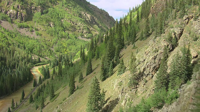 MS鸟瞰图的山坡出现在阴影到太阳与树木和河流山谷底部山谷/特柳赖德，科罗拉多州，美国视频素材