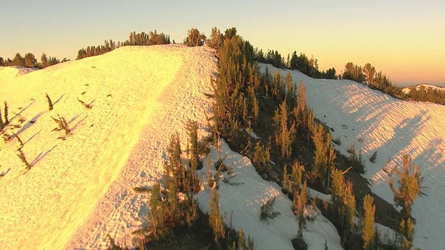 MS AERIAL Shot从内华达山脉的玫瑰山山顶到太浩湖的雪峰和天空中早晨粉红色的雾霾/内华达，美国视频素材