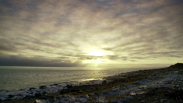 WS T/L在天空中的太阳与快速移动的云和海洋，冰冻的海滩/ Arviat, Nunavut，加拿大视频素材