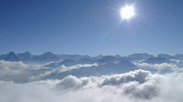 瑞士阿尔卑斯山上的阳光和蓝天，云雾缭绕的山峰视频素材