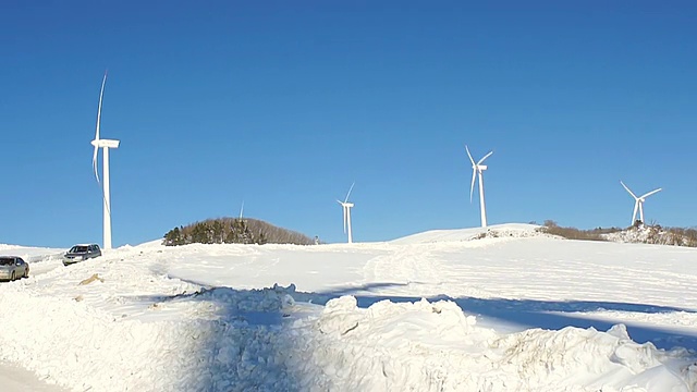 图为韩国江原道平昌大墙岭白雪覆盖的山上的风力发电机视频素材