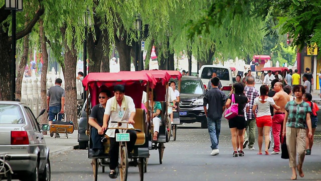 黄包车司机带着游客游览后海湖区/北京，中国视频素材