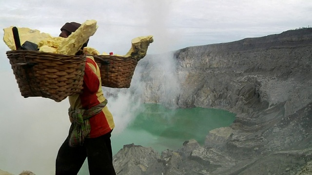 印度尼西亚爪哇伊真火山，一名男子正从伊真火山带着硫磺走向有毒云团视频素材