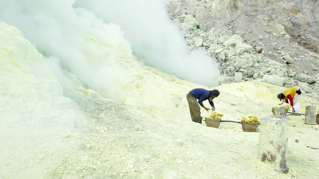 印度尼西亚爪哇伊真火山火山气体附近的伊真火山硫磺提取工作的矿工视频素材