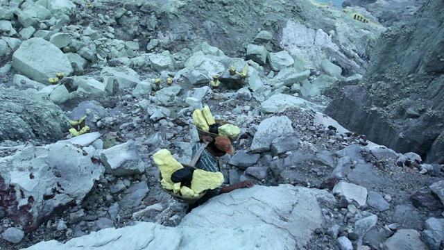 印度尼西亚爪哇伊真，一名矿工携带硫磺爬上伊真火山口视频素材