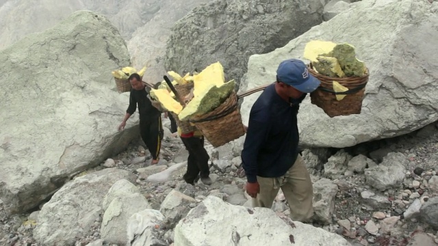 印度尼西亚爪哇，矿工携带固体硫磺爬上伊真火山口视频素材