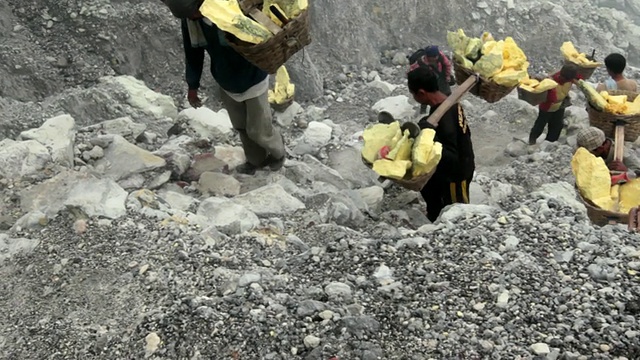 印度尼西亚爪哇，矿工携带固体硫磺爬上伊真火山口视频素材