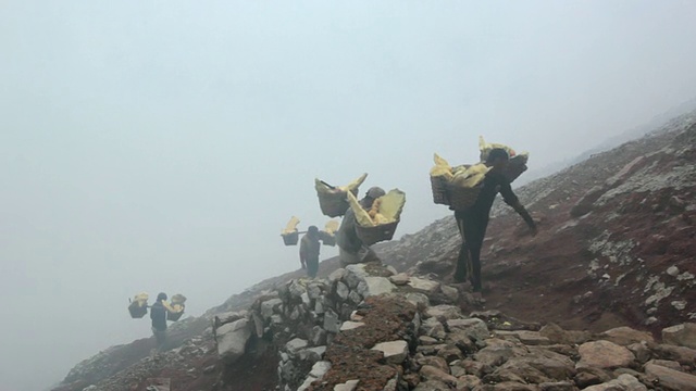 印度尼西亚爪哇，矿工携带固体硫磺爬上伊真火山口视频素材