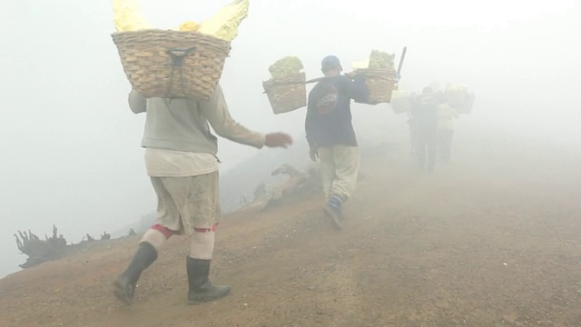 印度尼西亚爪哇岛，矿工们在携带固体硫的有毒气体中攀登伊真火山视频素材