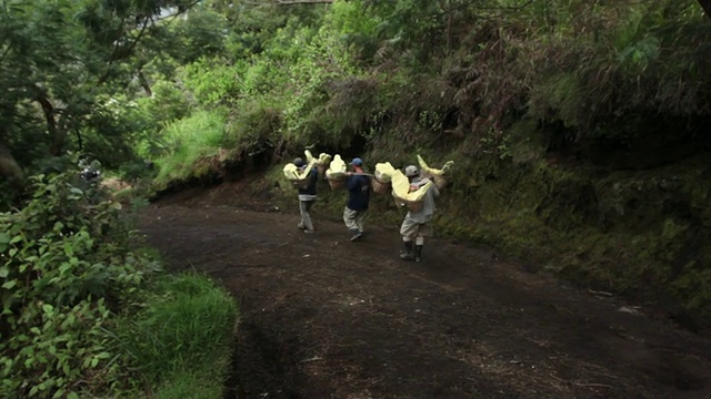 从印度尼西亚爪哇岛伊真火山携带固体硫的矿工视频素材