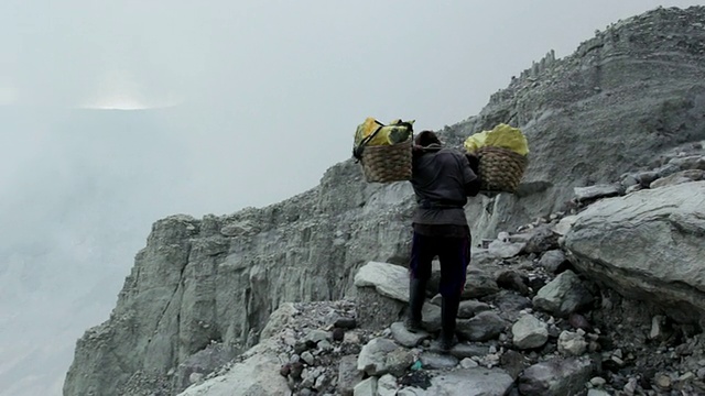 WS矿工携带硫磺爬上伊真火山口，爪哇，印度尼西亚视频素材