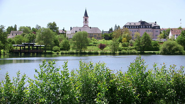 带教堂和市政厅的湖景/ Weiskirchen，萨尔州，德国视频素材