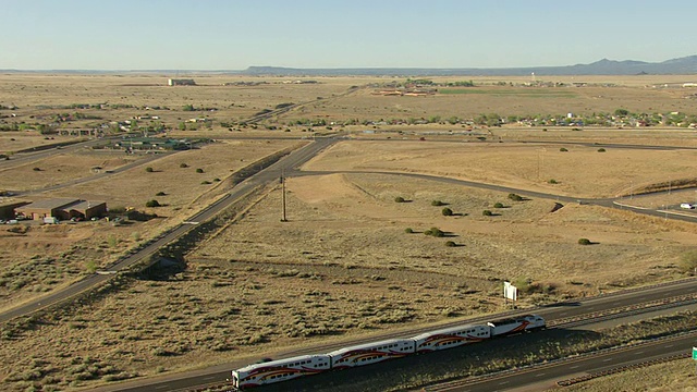 美国新墨西哥州，Railrunner Express在平地和山区轨道上运行的鸟瞰图视频素材