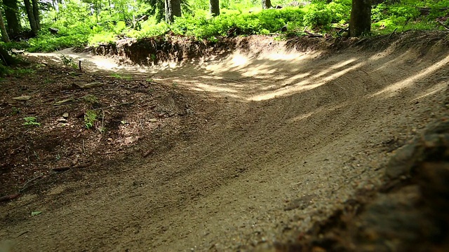 山地车在绿色的森林里骑车下山视频素材