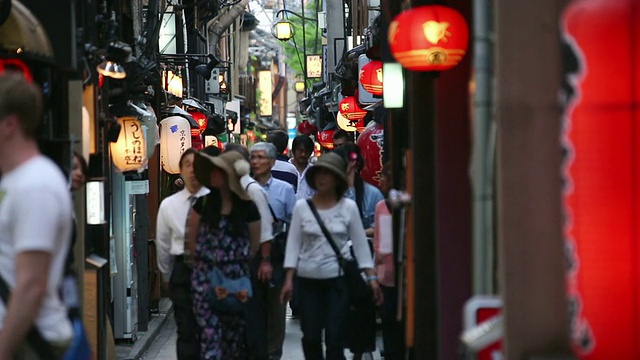 日本京都，人们在黄昏时走在街上，许多纸灯笼被风摇动视频素材