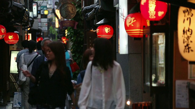 日本京都，人们在黄昏时走在街上，许多纸灯笼被风摇动视频素材