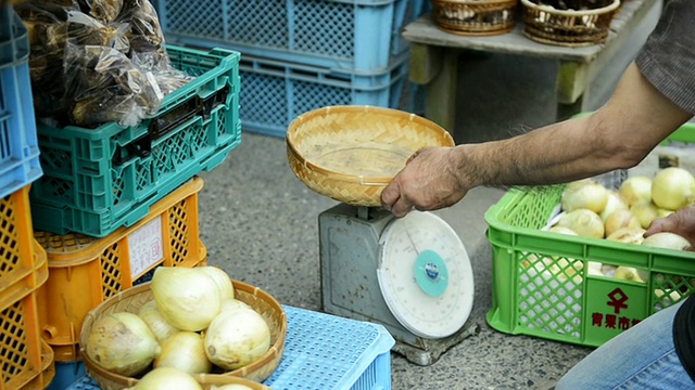 来自日本兵库市丰邑市的一位蔬菜水果商给洋葱称重视频素材