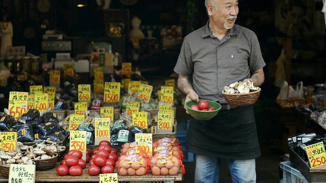 潘女士:日本兵库市丰邑市，一名蔬菜水果商师傅站在商店前做销售视频素材