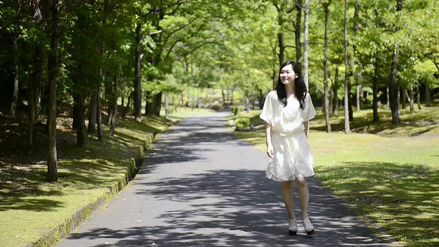 日本京都宇次，一名女子走在绿色公园的路上视频素材