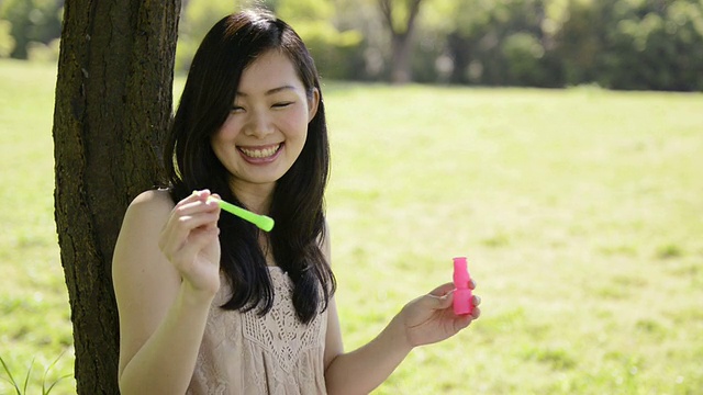 女人在树下玩肥皂泡的MS Shot /宇次，日本京都视频素材