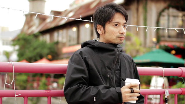 MS Shot of Man looking around and drinking coffee / Chatan，冲绳，日本视频素材