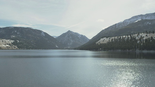 在阳光明媚的冬日里，瓦洛瓦湖的景色闪闪发光，后面是高耸的雪山，来自俄勒冈“小瑞士”/约瑟夫，俄勒冈，美国视频下载