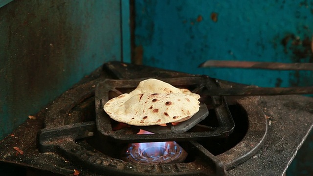 印度德里，一名男子正在用煤气煮面包(Roti或Chapatti)视频素材