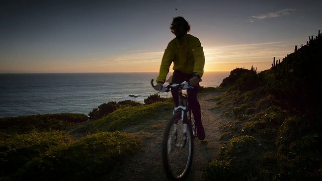 WS SLO MO POV男子骑自行车俯瞰Ocean / Port Orford Heads State Park，俄勒冈州，美国视频素材