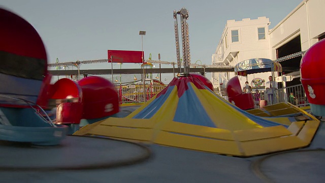 在泽西海岸的一个游乐园里，很多家庭都在玩“Tilt a Whirl”。视频素材