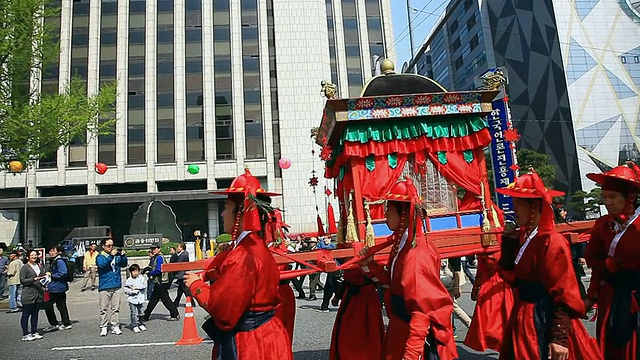 MS TS韩国首尔，传统的韩国服饰游行队伍抬着轿子穿过市政厅广场视频素材