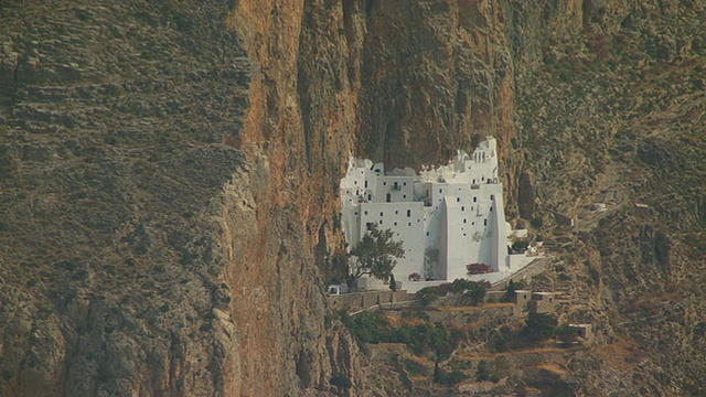 WS ZO鸟瞰图在岩石墙与小镇和海岸/ Amorgos，基克拉迪斯，希腊视频素材