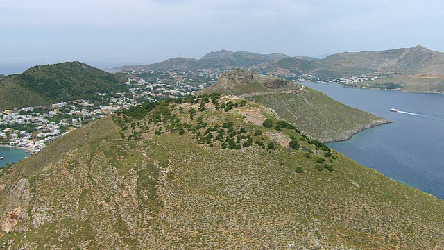 海岸鸟瞰图与山脉和城市/勒罗斯，基克拉迪斯，希腊视频素材