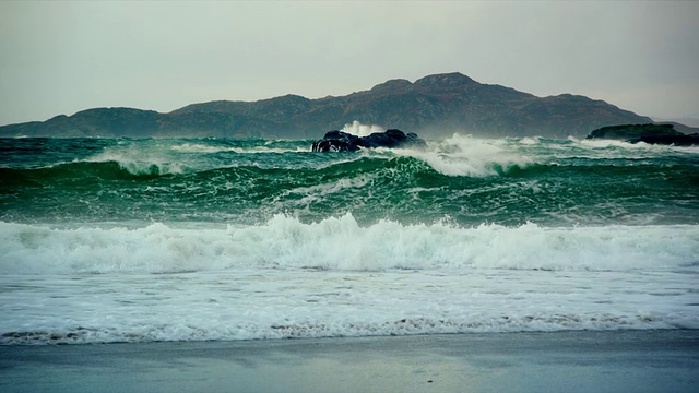 搅动的海浪打破海滩和岩石与云/德拉姆贝格，苏格兰，英国视频素材