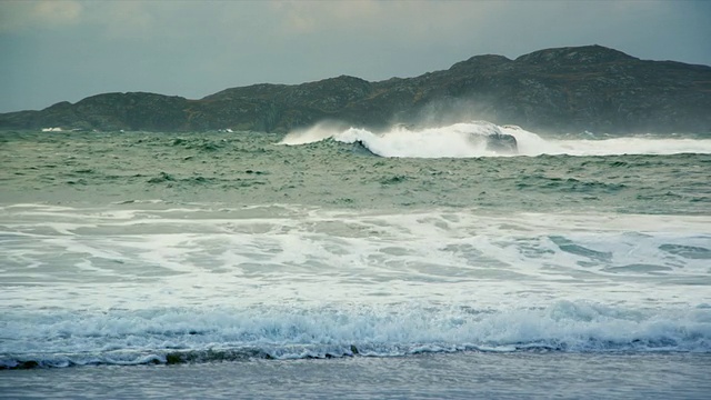 搅动的海浪打破海滩与云/德拉姆贝格，苏格兰，英国视频素材