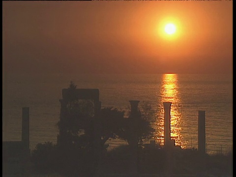 海面上的夕阳在黎巴嫩的前景中勾勒出废墟和柱子的轮廓视频素材