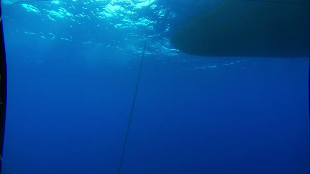 阳光透过一艘漂浮船只附近的海水。高清。视频素材