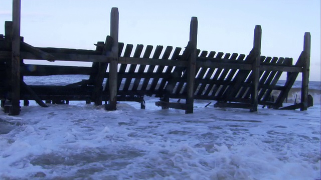 海浪冲刷海岸围栏在happisburgh，英国。视频素材