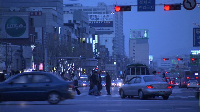 行人穿过首尔繁忙的城市街道。高清。视频素材