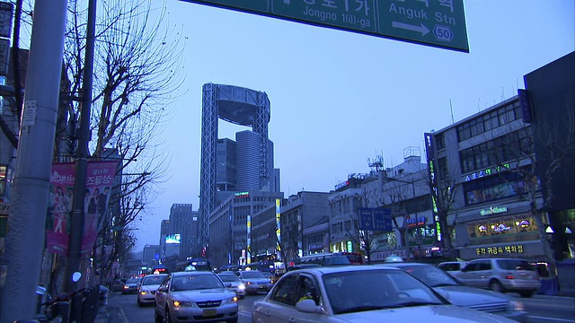 交通沿着繁忙的城市街道经过多层的店面首尔。高清。视频素材