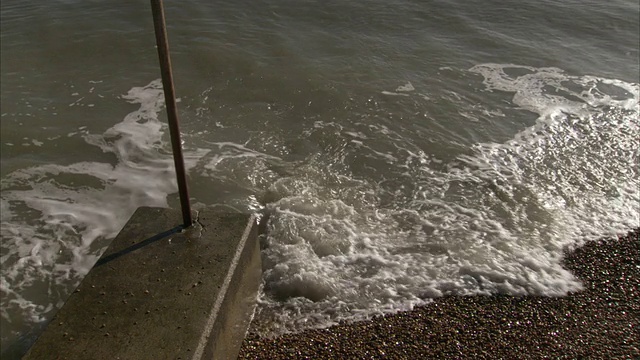 海浪冲刷着岩石海岸线和水泥码头。视频素材