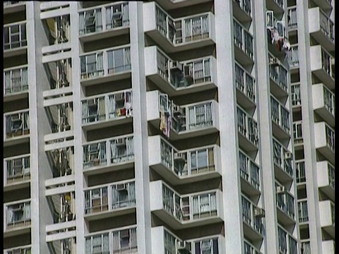 在香港的高楼大厦中，从蓝天下倾斜的公寓视频素材