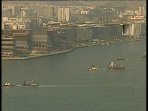 从穿过海港的船只缩小到前景中的大船和香港后面的城市视频素材