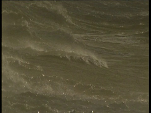 英国，海浪冲过摄像机，喷出大量泡沫和浪花，然后沉入波涛汹涌的海面视频素材