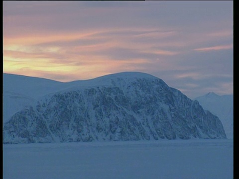 盘上留下了覆盖着皑皑白雪的风景，盘上留下了浅橙色的天空视频素材