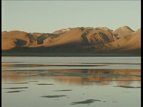 在黄昏的天空下，潘留下的盐湖和休眠的火山倒映在水中视频素材