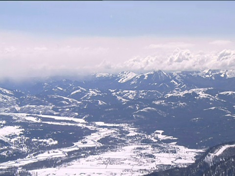 雪峰的山脉和山谷，在云雾之下的山脉和巨大的山峰的全景视频素材